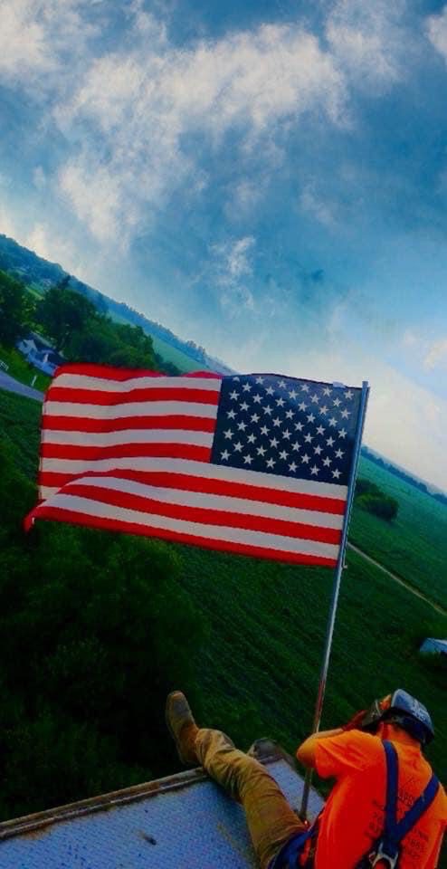 Man welding and repairing with a USA flag