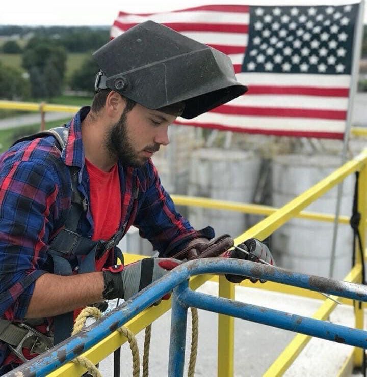 Man welding while wearing a protective cover